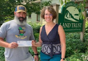 Trent of Bridge Up Brewing craft beer brewery and taprooms in Door County donates a check