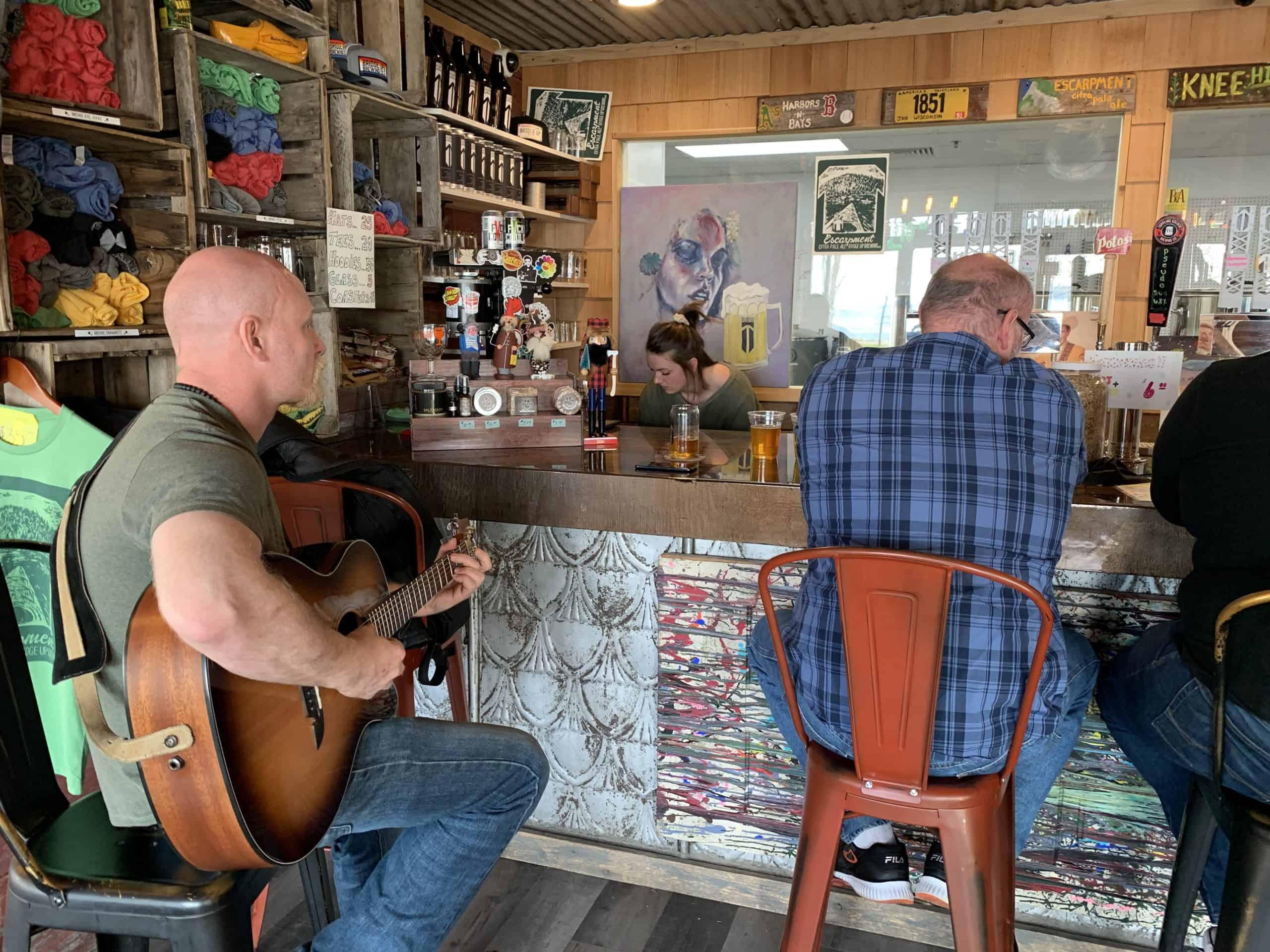 Guitarist plays live music at the bar of at Bridge Up Brewing craft beer brewery and taprooms in Door County Wisconsin