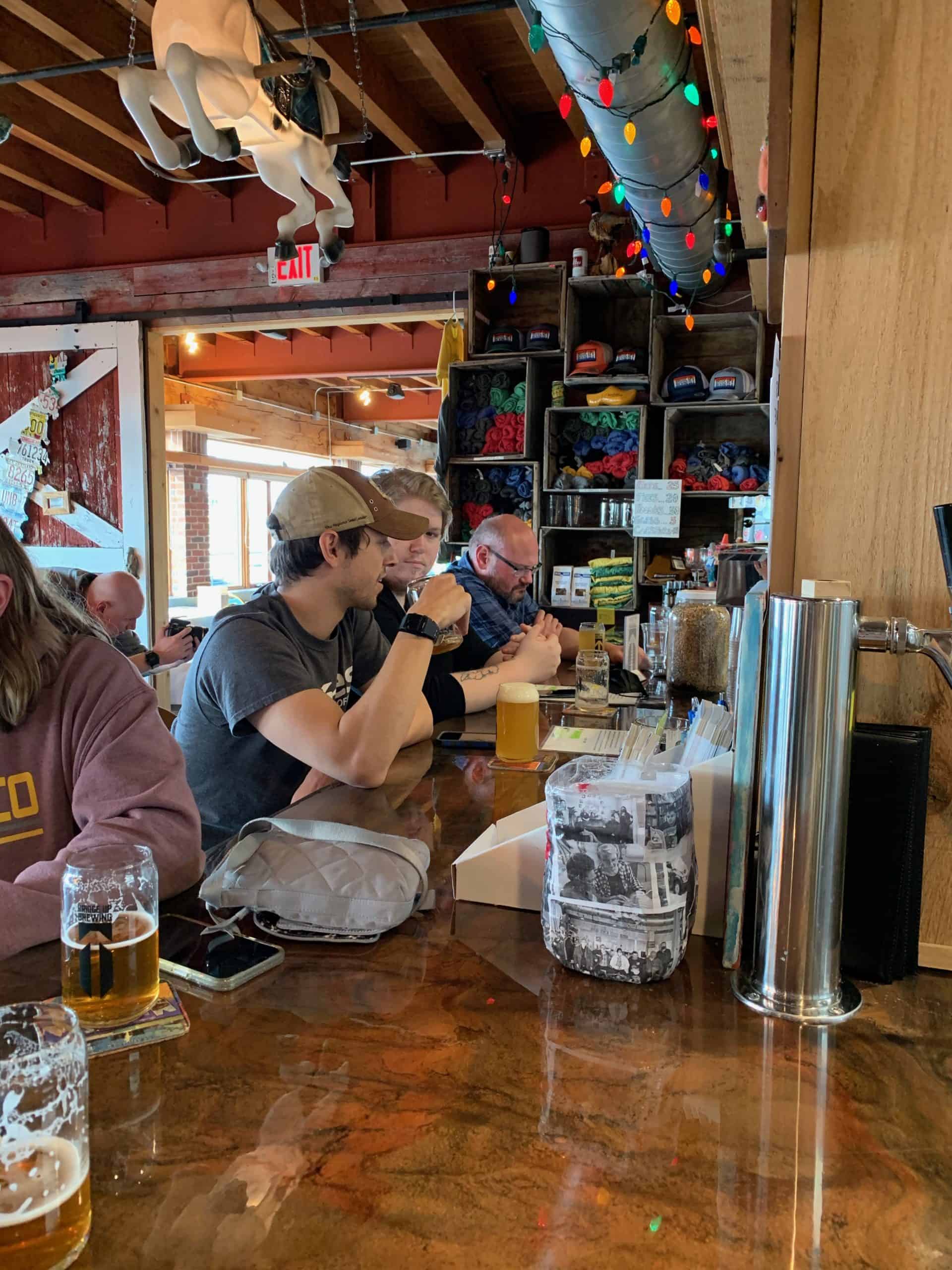 Guests enjoy beer seated at taproom bar at Bridge Up Brewing craft beer brewery and taprooms in Door County Wisconsin